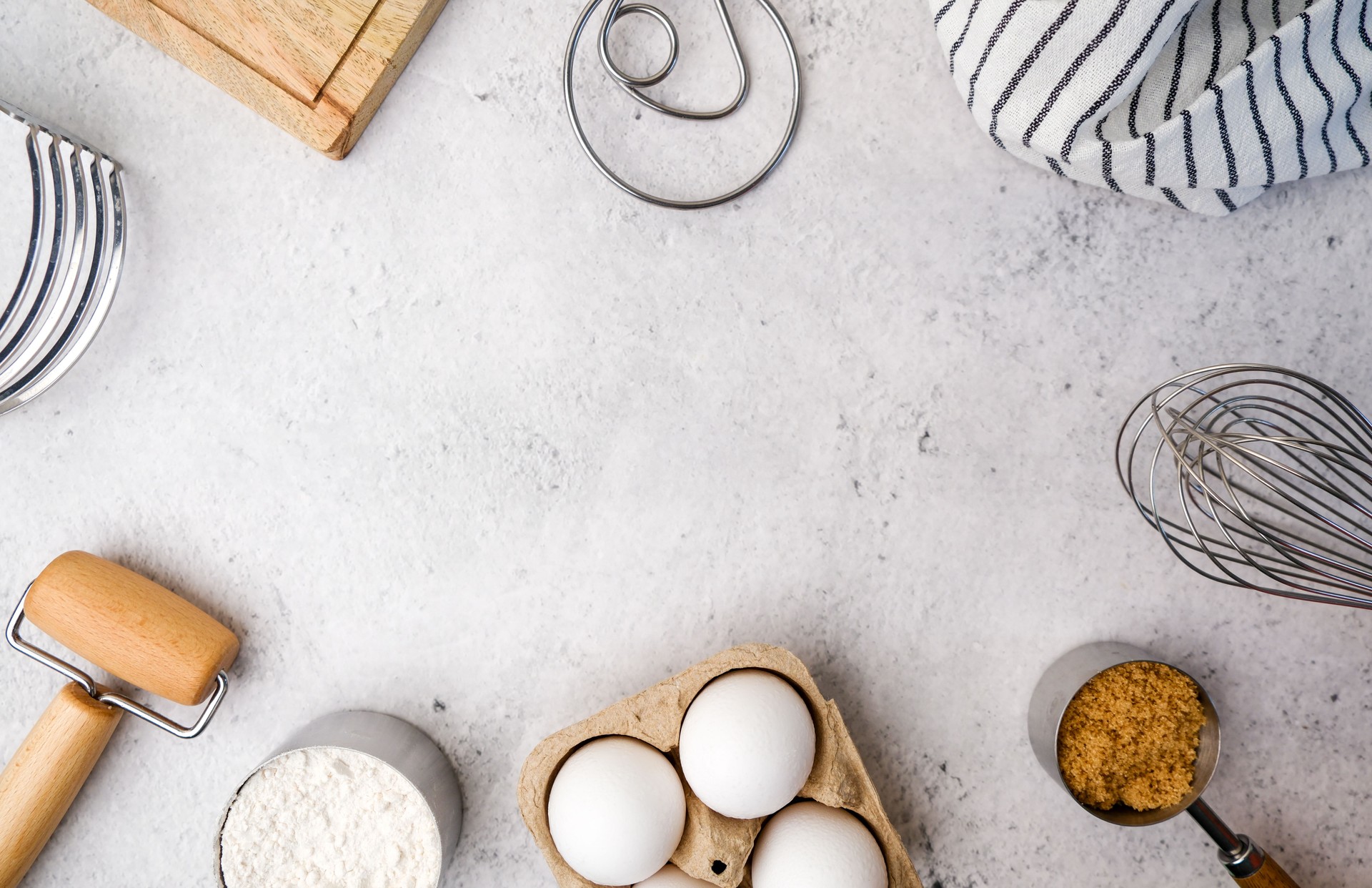 Baking pastry ingredients include brown sugar, flour, eggs and with wooden utensil on light stone concrete, top view, flatlay with copy space